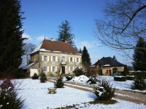 una grande casa con la neve davanti di Château Bel-Air a Villers-Farlay