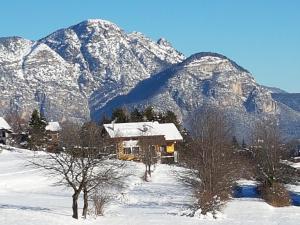 una casa en la nieve frente a una montaña en Casa Solaris, en Fai della Paganella