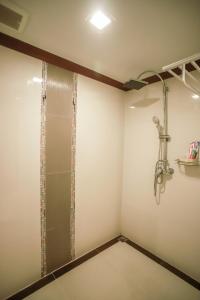 a walk in shower in a bathroom with white walls at Korat Hotel - SHA Plus in Nakhon Ratchasima