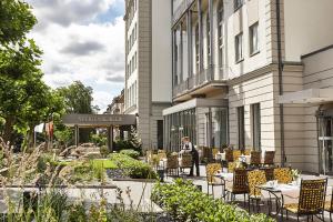 a person sitting at a table outside of a building at Steigenberger Hotel Bad Homburg in Bad Homburg vor der Höhe