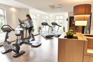 a woman exercising on exercise bikes in a gym at Steigenberger Hotel Bad Homburg in Bad Homburg vor der Höhe