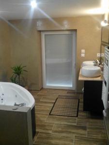 uma casa de banho com uma banheira, 2 lavatórios e uma janela em Chambre ZEN em Panazol