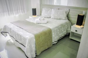 a bedroom with a large bed with two lamps on it at Apple Flat Natal in Natal