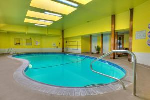 a large swimming pool in a large room with yellow walls at Legacy Vacation Resorts - Reno in Reno