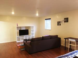 a living room with a couch and a flat screen tv at Private Unit / Private Bathroom Near BART & SF in Daly City