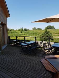 a deck with tables and chairs and an umbrella at Gite de prejeurin in Échalas