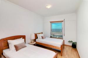 Baltico Residence في لشبونة: غرفة نوم بسريرين ونافذة