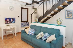 ein Wohnzimmer mit einem blauen Sofa und einer Treppe in der Unterkunft Casa Vacanze Torre dei Gualtieri in San Benedetto del Tronto