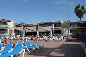 un gruppo di persone seduti su sedie a sdraio in un resort di Beautiful Apartment Hercules a Costa Del Silencio