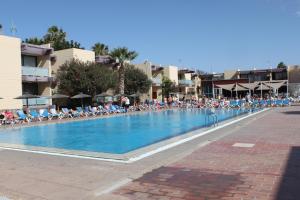 una grande piscina con persone sedute sulle sedie di Beautiful Apartment Hercules a Costa Del Silencio Altre 38 foto