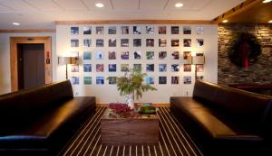 a lobby with two leather couches and a wall with pictures at Jay Peak Resort in Jay