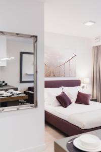 a bedroom with a large mirror and a bed at LuxLux Apartments Metro Slodowiec in Warsaw