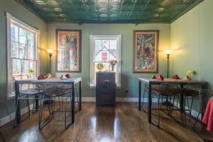 a room with tables and chairs and paintings on the walls at Agustin Inn - Saint Augustine - Adults Only in St. Augustine