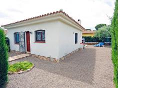 a white house with a red door and a gravel driveway at Rentalmar Casa Horus in Miami Platja