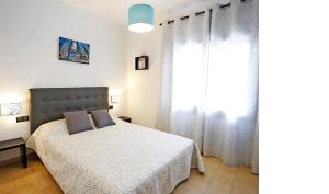 um quarto com uma cama e uma grande janela em Rentalmar Casa Horus em Miami Platja