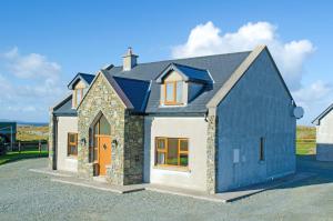 een blauw-wit huis met een garage bij Cottage 238 – Cleggan in Cleggan