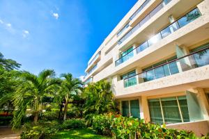 an apartment building with palm trees and plants at Estelar Playa Manzanillo - All inclusive in Cartagena de Indias