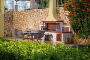 a patio with a table and chairs and a fireplace at Azzuro Villa with private pool by Estia in Hersonissos