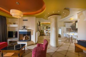 a living room with a fireplace and a dining room at Azzuro Villa with private pool by Estia in Hersonissos