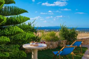 a table with two chairs and a table with wine glasses at Azzuro Villa with private pool by Estia in Hersonissos +33 photos