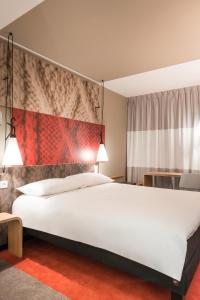 パリにあるイビス‐パリ‐ガールドゥノール ラファイエットのベッドルーム1室(白い大型ベッド1台付)