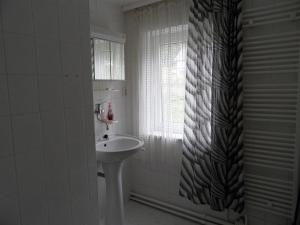 a white bathroom with a sink and a window at Penzion SPICAK in Železná Ruda