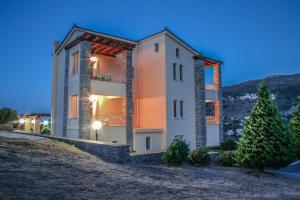 una casa por la noche con las luces encendidas en Villa View Studios, en Ándros