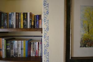 a book shelf filled with books next to a wall at Appartamento Valentino in Cortona