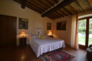 una camera da letto con un letto, due lampade e una finestra di Appartamento Valentino a Cortona Altre 17 foto