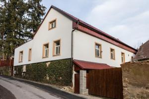 Biały dom z czerwonym dachem w obiekcie Attic Rooms Tábor w Taborze