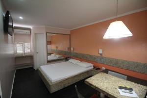 a small room with a bed and a mirror at Hotel Colonial (Adult Only) in Olinda