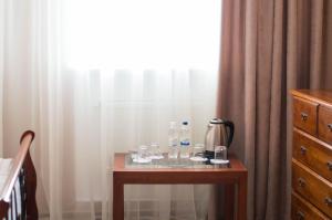 a table with glasses on it next to a window at Pallada Hotel in Ternopil