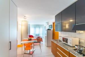 a kitchen with a table and chairs in a room at Laguna Grande monolocali in Bibione