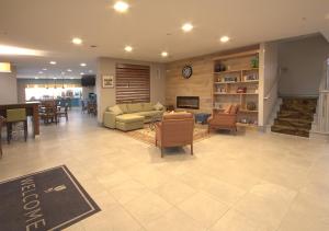 a living room with a couch and tables and chairs at Country Inn & Suites by Radisson, Moline Airport, IL in Moline