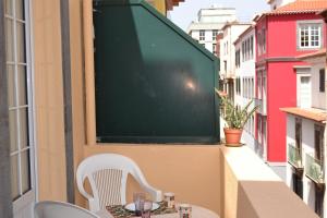 a table and chairs on a balcony with a chalkboard at Central Suite in Funchal 3N in Funchal