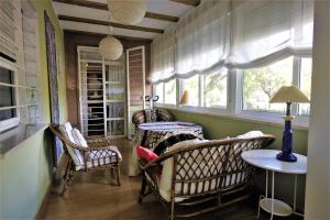 a room with chairs and a table and windows at Acogedor Apart de 2 dormitorios en C.Expo, SEVILLA in Mairena del Aljarafe