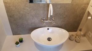 a white sink in a bathroom with a fosset at Art House in Tbilisi City +34 photos