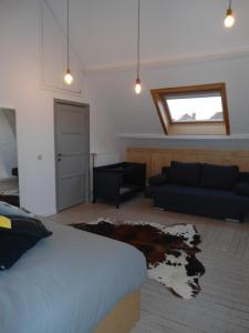 een slaapkamer met een bed en een bank bij Huize Hertog in Brugge