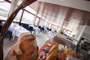 una sala da pranzo con tavoli, sedie e finestre di Park - Hotel Inseli a Romanshorn