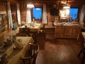 ein Esszimmer mit 2 Tischen und eine Küche in der Unterkunft Pension Fürhapter mit Bio- Bauernhof in Sankt Jakob in Defereggen