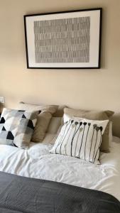 ein weißes Bett mit Kissen und einem Bild an der Wand in der Unterkunft Apartamento Costa Ballena in Rota + 45 Fotos