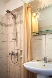 La salle de bains est pourvue d'un lavabo et d'une douche. dans l'établissement Villa View Studios, à Andros