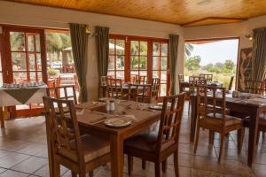 a dining room with tables and chairs and windows at Rössmund Lodge in Swakopmund