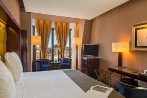 a hotel room with a bed and a television at Hotel Casa Fuster G.L Monumento in Barcelona
