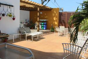 - une terrasse avec un bouquet de chaises et de tables dans l'établissement Hospedaje Solymar Sarie Bay, à San Andrés