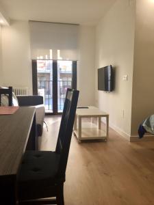 a living room with a table and a tv at Puente Romano by Salamancavacacional in Salamanca