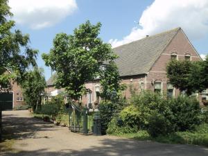 a brick house with a gate in front of it at B&B De Kaagse Koe in Huigsloot