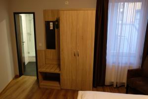 a room with a dresser and a wooden door at Minx – CityHotels in Aachen