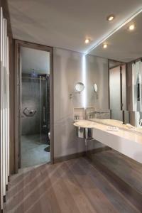 a bathroom with a sink, mirror, and bathtub at Inntu Hotel in Medellín