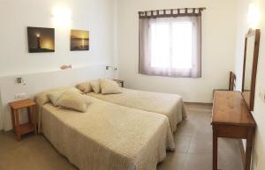 a bedroom with two beds and a window at Vivendes Adelina - Escapada Formentera in Es Pujols